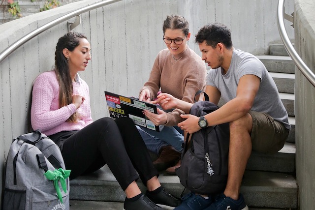 Studierende schauen auf einen Laptop